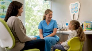 Dental hygienist checking mother and child