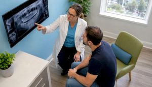 Dentist showing dental X-rays to patient